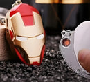 Red and gold Iron Man helmet keychain on a textured surface with a blurred background