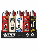 A retail display tray of BIC lighters with motivational fitness graphics. The display features four distinct lighters in red, cream, white, and black, each with a graphic of a weightlifter and text like 'STAY STRONG', 'RATTLEBELL HARD', 'TRAIN HARD', and 'DEADLIFT LIKE A PRO'.