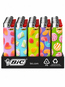 A BIC lighter display featuring four colorful patterned lighter bodies with red tips, arranged in a black retail tray with BIC branding and recycling icons.