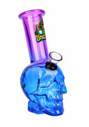 Blue skull-shaped bong with purple neck and green label on a white background