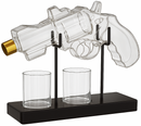 Clear glass revolver with two shot glasses on a black stand