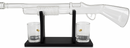 Glass gun-shaped shot glass set on a black stand with two clear glasses.